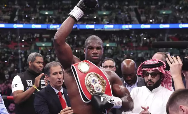 Daniel Dubois, center, celebrates victory against Anthony Joshua, not pictured, in the IBF World Heavyweight bout at Wembley Stadium, in London, Saturday, Sept. 21, 2024. (Bradley Collyer/PA via AP)