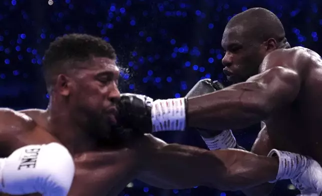 Anthony Joshua, left, and Daniel Dubois, fight in the IBF World Heavyweight bout at Wembley Stadium, in London, Saturday, Sept. 21, 2024. (Bradley Collyer/PA via AP)