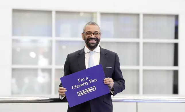 Former British Foreign Secretary James Cleverly holds up a sign with his name after appearing on the Sunday Morning with Trevor Phillips show ahead of the Conservatives annual conference where a new leader will be chosen, in Birmingham, England, Sunday, Sept. 29, 2024. (Stefan Rousseau/PA via AP)