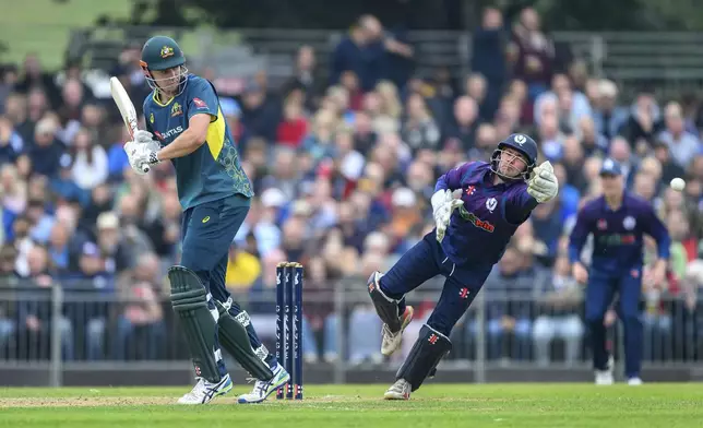 Australia's Cameron Green, left, edges the ball past Scotland's Matthew Cross, right, during the third T20 International test match between Scotland and Australia in Edinburgh, Scotland, Saturday, Sept. 7, 2024. (Malcolm Mackenzie/PA via AP)