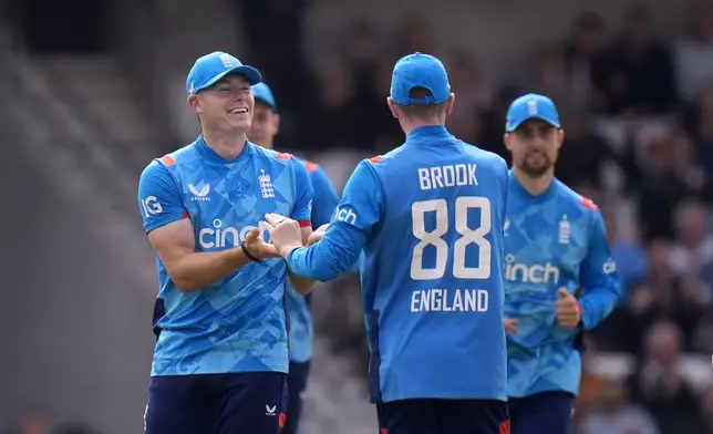 England's Matthew Potts, left, celebrates taking the catch to dismiss Australia's Mitchell Starc during the second One Day international match between England and Australia at Headingley, Leeds, Saturday Sept. 21, 2024. (Danny Lawson/PA via AP)