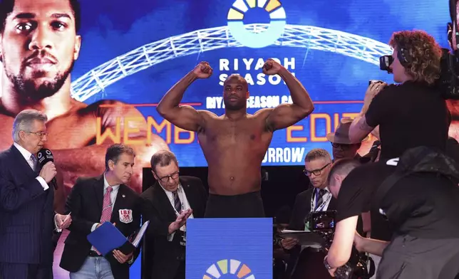 Boxer Daniel Dubois stands on the scale during the weigh-in at Trafalgar Squar ,in London, Friday, Sept. 20, 2024, for his upcoming IBF heavyweight title fight against Anthony Joshua. (Bradley Collyer/PA via AP)