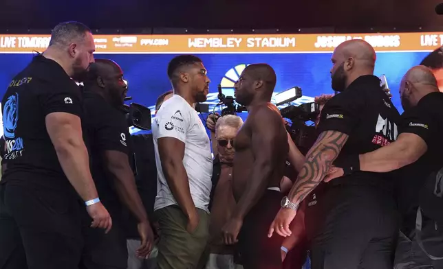 Boxers Anthony Joshua, center left, and Daniel Dubois faceoff during the weigh-in at Trafalgar Square in London, Friday, Sept. 20, 2024, for their upcoming IBF heavyweight title fight. (Bradley Collyer/PA via AP)