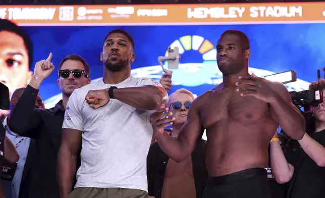 Boxers Anthony Joshua, left, and Daniel Dubois pose during the weigh-in at Trafalgar Square in London, Friday, Sept. 20, 2024, for their upcoming IBF heavyweight title fight. (Bradley Collyer/PA via AP)