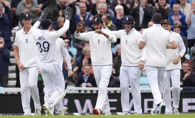 England's Shoaib Bashir, center, celebrates with team-mates after taking the catch of Sri Lanka's Kusal Mendis on day four of the Third Rothesay Men's Test at The Kia Oval, London, Monday Sept. 9, 2024. (John Walton/PA via AP)