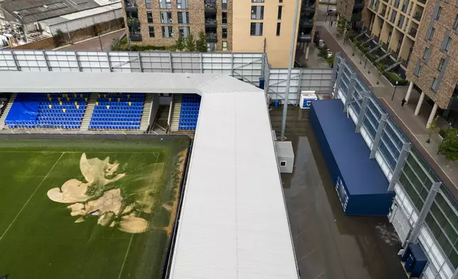 An aerial view of a sinkhole on the pitch and flooded walkways at the Cherry Red Records Stadium, home of AFC Wimbledon, in London, Monday, Sept. 23, 2024, after heavy rainfall. (Jordan Pettitt/PA via AP)