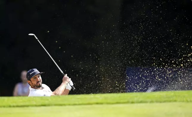 Mark Hubbard of the United States chips out of a bunker on the 1st during day two of the 2024 BMW PGA Championship at Wentworth Golf Club in Virginia Water, England, Friday Sept. 20, 2024. (Zac Goodwin/PA via AP)