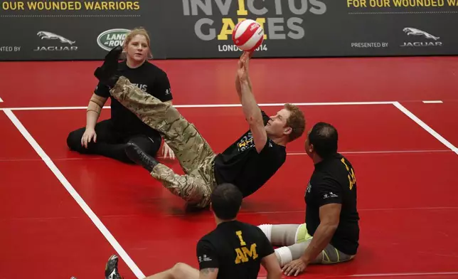 FILE Britain Prince Harry, center, plays a game of sitting volleyball during the launch of the Invictus Games for wounded warriors at the Copper Box arena in the Queen Elizabeth Olympic Park in London, Thursday, March 6, 2014. (AP Photo/Sang Tan, File)