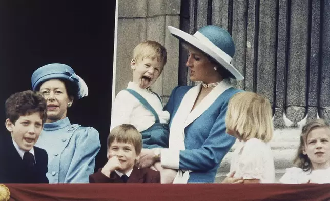 FILE - Britain's Prince Harry sticks out his tongue for the cameras on the balcony of Buckingham Palace in London, England on June 11, 1988, following the Trooping of the Colour. (AP Photo/Steve Holland, File)