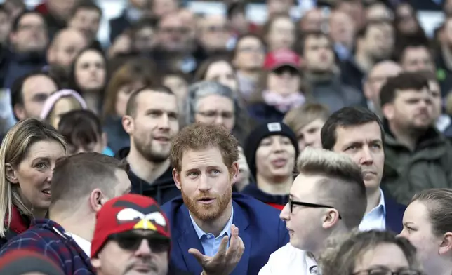 FILE - In this Feb. 17, 2017 file photo Britain's Prince Harry speaks with people from the RFU Try for Change programme during a visit to an England Rugby Squad training session at Twickenham Stadium in London. Harry and Meghan stepped away from full-time royal life in early 2020, and Buckingham Palace on Friday Feb. 19, 2021, confirmed the couple will not be returning to royal duties, and Harry will give up his honorary military titles. (AP Photo/Kirsty Wigglesworth, pool, File)