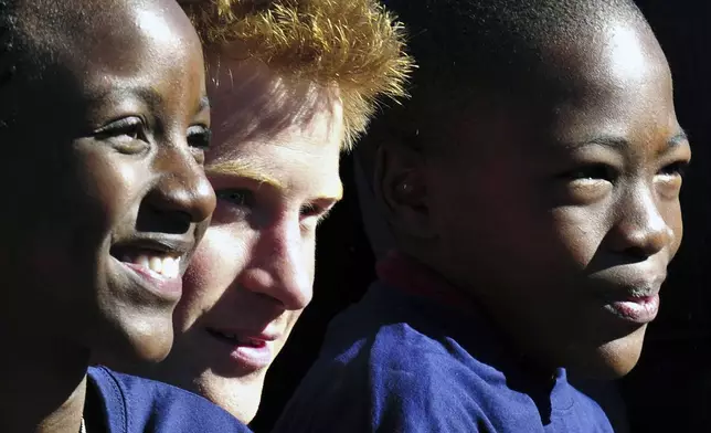 FILE - Britain's Prince Harry poses with children from the Mophane Primary school, in Gaborone, Botswana, Tuesday, June 15, 2010. (AP Photo/Shayne Robinson, File)