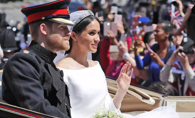 FILE - Britain's Prince Harry and his bride Meghan Markle, ride in a carriage after their wedding ceremony at St. George's Chapel in Windsor Castle in Windsor, near London, England, Saturday, May 19, 2018. (AP Photo/Frank Augstein, File)