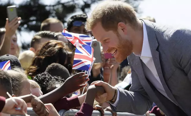 FILE - Britain's Prince Harry, The Duke of Sussex meets members of the public as he arrives for a visit to Barton Neighbourhood Centre in Oxford, England Tuesday, May 14, 2019. The centre is a hub for local residents which houses a doctor's surgery, food bank, cafe and youth club. (AP Photo/Kirsty Wigglesworth, Pool, File)