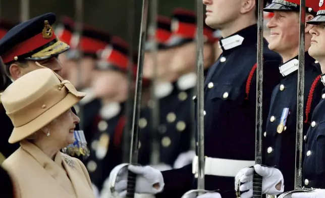 FILE - Britain's Prince Harry, second from right, grins as his grandmother Queen Elizabeth II smiles, as she inspects the Sovereign's Parade at the Royal Military Academy in Sandhurst, England, Wednesday, April 12, 2006. (AP Photo/Dylan Martinez, pool, File)