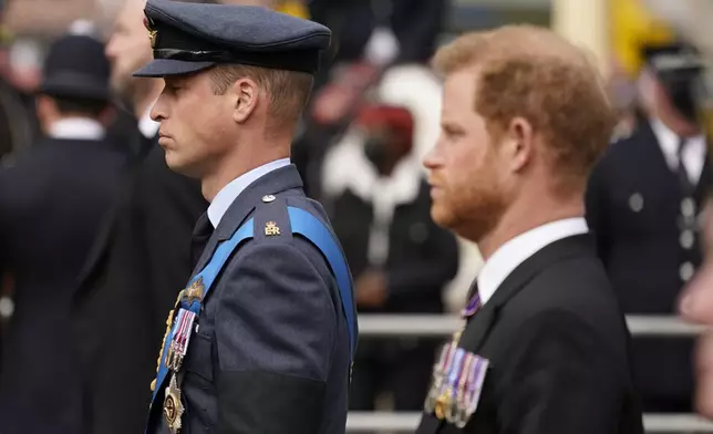 FILE - Prince William, center, and Prince Harry, right, walk behind the coffin of Queen Elizabeth II being pulled past Buckingham Palace following her funeral service at Westminster Abbey in central London, on Sept. 19, 2022. (AP Photo/Alberto Pezzali, File)