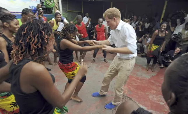 FILE - Britain's Prince Harry dances with a girl during a visit to the non-governmental organization RISE - Reaching Individuals through Skills and Education, in Kingston, Jamaica, Tuesday March 6, 2012. (AP Photo/Collin Reid, File)