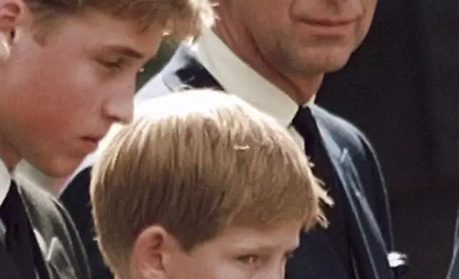 FILE - Britain's Prince Charles, the Prince of Wales, and his sons Prince William, left, and Prince Harry wait for the coffin of Princess Diana to be loaded into a hearse outside of Westminster Abbey, in London on Sept. 6, 1997. (John Gaps III/Pool Photo via AP, File)