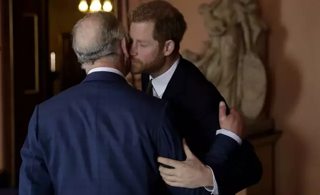 Britain's Prince Harry kisses and greets his father Prince Charles upon their separate arrival to attend a coral reef health and resilience meeting with speeches and a reception with delegates at Fishmongers Hall in London, Wednesday, Feb. 14, 2018. (AP Photo/Matt Dunham, Pool, File)