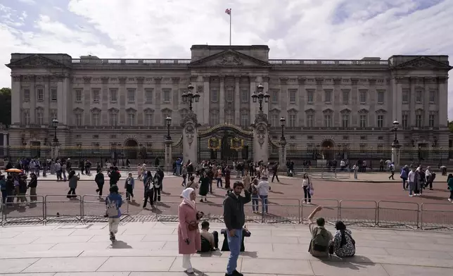 Tourists take photos and visit Buckingham Palace in London, Tuesday, Sept. 10, 2024. Kate, Princess of Wales announced Monday that she has completed chemotherapy treatment for cancer and plans to return to some public duties. (AP Photo/Alberto Pezzali)