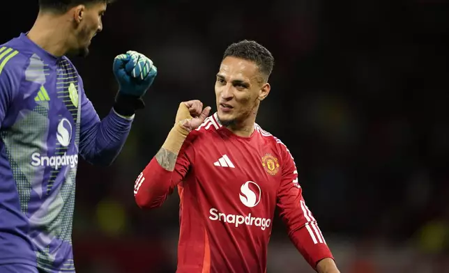 Manchester United's Antony, right, reacts to Manchester United's goalkeeper Altay Bayindir at halftime during the English League Cup soccer match between Manchester United and Barnsley at Old Trafford, Manchester, England, Tuesday, Sept. 17, 2024. (AP Photo/Dave Thompson)