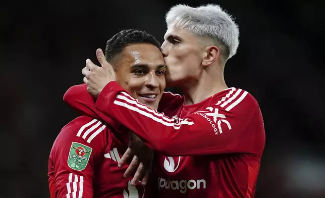 Manchester United's Antony, left, celebrates scoring with Alejandro Garnacho during the English League Cup soccer match between Manchester United and Barnsley at Old Trafford, Manchester, England, Tuesday, Sept. 17, 2024. (Mike Egerton/PA via AP)