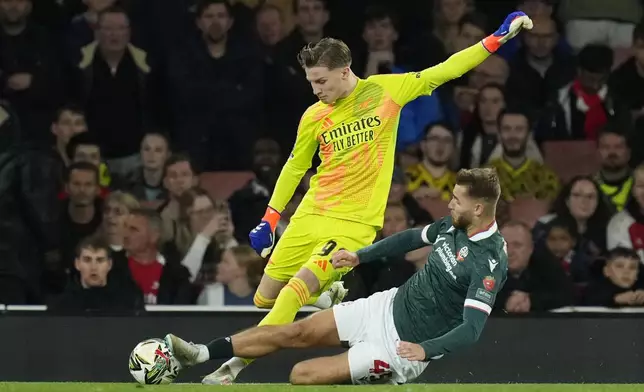 Arsenal's 16-year-old goalkeeper Jack Porter, left, is challenged by Bolton's John McAtee during the English League Cup third round soccer match between Arsenal and Bolton Wanderers at the Emirates stadium in London, Wednesday, Sept. 25, 2024. (AP Photo/Kirsty Wigglesworth)