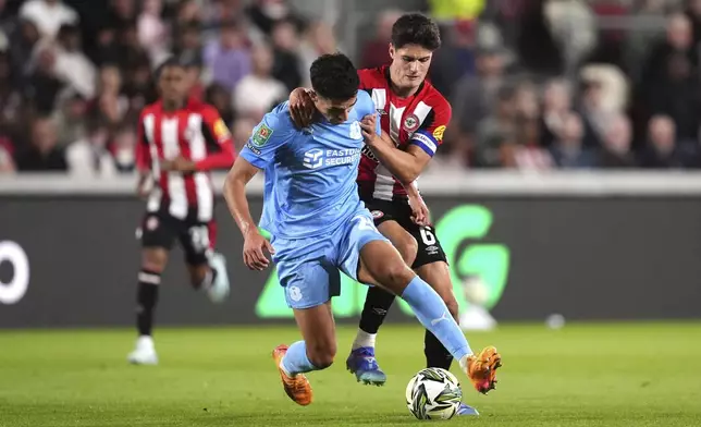 Leyton Orient's Sonny Perkins, left, and Brentford's Christian Norgaard battle for the ball during the English League Cup third round soccer match at the Gtech Community Stadium, Brentford, Tuesday Sept. 17, 2024. (John Walton/PA via AP)