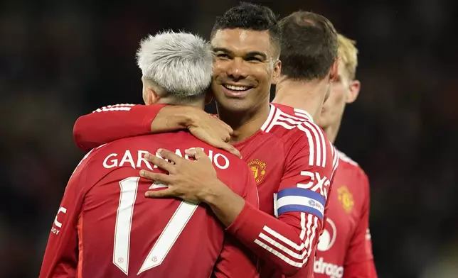 Manchester United's Alejandro Garnacho is celebrated by Manchester United's Casemiro after scoring his side's fourth goal during the English League Cup soccer match between Manchester United and Barnsley at Old Trafford, Manchester, England, Tuesday, Sept. 17, 2024. (AP Photo/Dave Thompson)