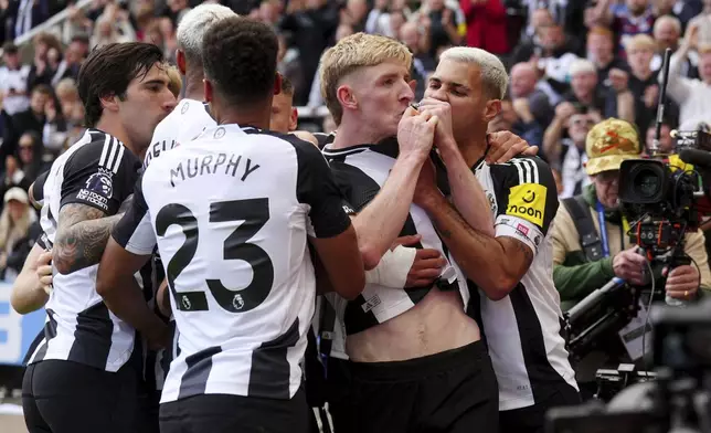 Newcastle United's Anthony Gordon, center, celebrates with teammates after scoring the equalizing goal from the penalty spot during the Premier League match between Newcastle and Manchester City, at St James' Park, Newcastle upon Tyne, England, Saturday Sept. 28, 2024. (Owen Humphreys/PA via AP)