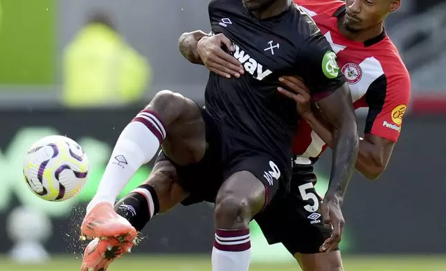 West Ham United's Michail Antonio (left) and Brentford's Ethan Pinnock battle for the ball during the British Premier League soccer match between West Ham and Brentford, at the Gtech Community Stadium, London, Saturday Sept. 28, 2024. (John Walton/PA via AP)