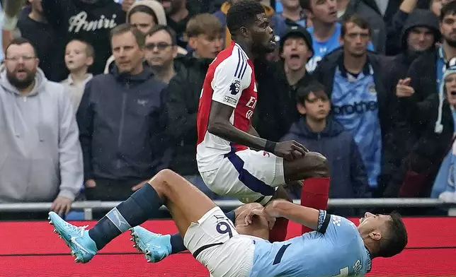 Manchester City's Rodri is injured next to Arsenal's Thomas Partey during the English Premier League soccer match between Manchester City and Arsenal at the Etihad stadium in Manchester, England, Sunday, Sept. 22, 2024. (AP Photo/Dave Thompson)