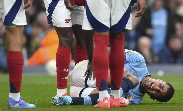 Manchester City's Rodri reacts to an injury, during the English Premier League soccer match between Manchester City and Arsenal at the Etihad stadium in Manchester, England, Sunday, Sept. 22, 2024. (Martin Rickett/PA via AP)