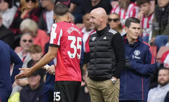 Southampton's Jan Bednarek speaks to Manchester United's head coach Erik ten Hag during the English Premier League soccer match between Southampton and Manchester United at St. Mary's stadium in Southampton, England, Saturday, Sept. 14, 2024. (AP Photo/Alastair Grant)