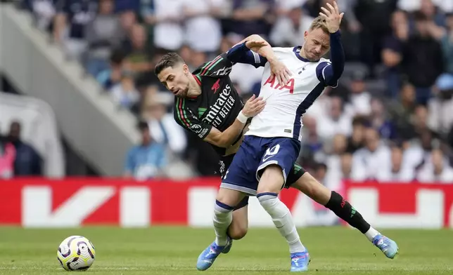 Tottenham's James Maddison is pulled back by Arsenal's Jorginho during the English Premier League soccer match between Tottenham Hotspur and Arsenal in London, Sunday, Sept. 15, 2024. (AP Photo/Kin Cheung)