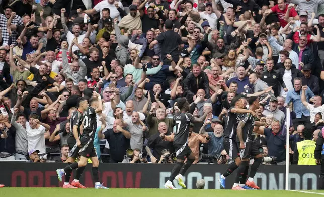 Arsenal's Gabriel, right, celebrates with teammates after scoring the opening goal during the English Premier League soccer match between Tottenham Hotspur and Arsenal in London, Sunday, Sept. 15, 2024. (AP Photo/Kin Cheung)