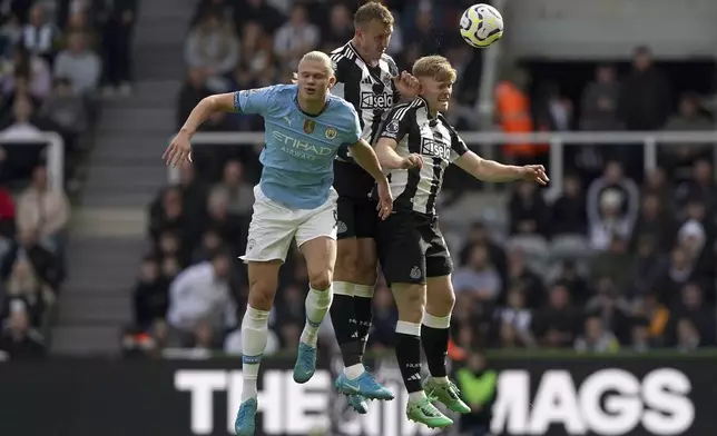 Manchester City's Erling Haaland, left, battles for the ball with Newcastle United's Dan Burn, center, and Lewis Hall during the Premier League match between Newcastle and Manchester City, at St James' Park, Newcastle upon Tyne, England, Saturday Sept. 28, 2024. (Owen Humphreys/PA via AP)