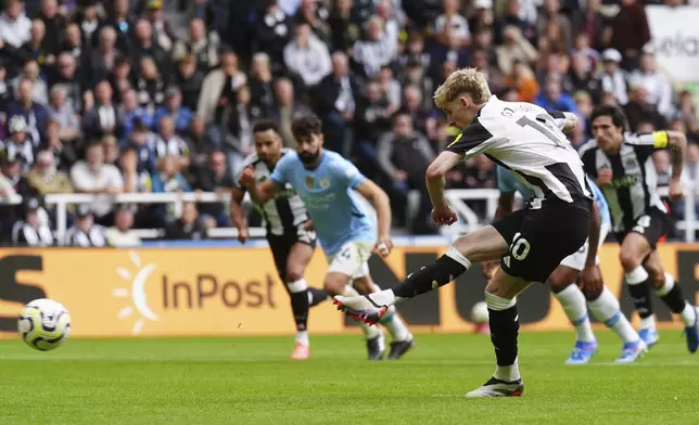 Newcastle United's Anthony Gordon shoots to score the equalizing goal from a penalty spot during the Premier League match between Newcastle and Manchester City, at St James' Park, Newcastle upon Tyne, England, Saturday Sept. 28, 2024. (Owen Humphreys/PA via AP)