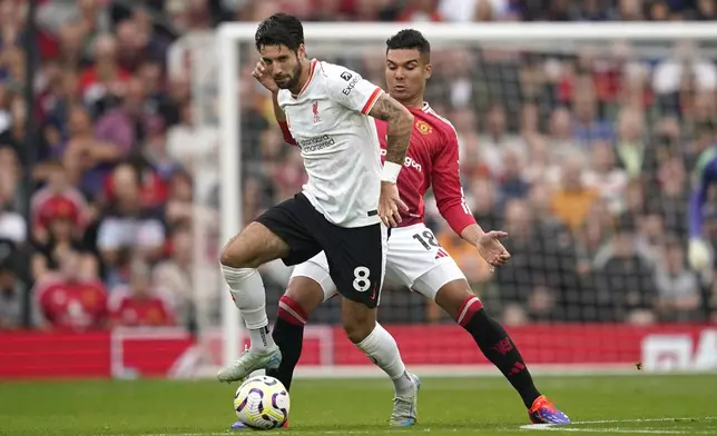 Liverpool's Dominik Szoboszlai, left, challenges for the ball with Manchester United's Casemiro during the English Premier League soccer match between Manchester United and Liverpool at Old Trafford, Sunday, Sept. 1, 2024, in Manchester, England. (AP Photo/Dave Thompson)