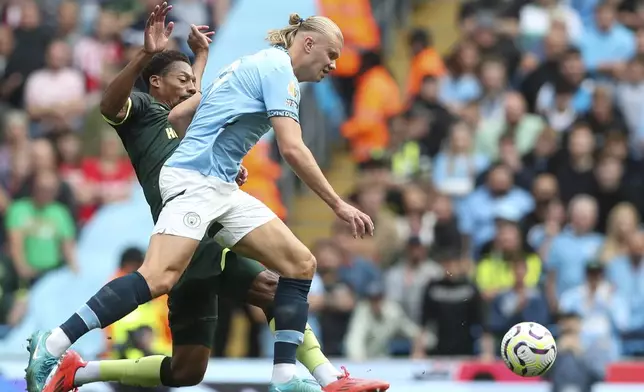 Manchester City's Erling Haaland, front, duels for the ball with Brentford's Ethan Pinnock during the English Premier League soccer match between Manchester City and Brentford at the Etihad Stadium in Manchester, England, Saturday, Sept. 14, 2024. (AP Photo/Scott Heppel)