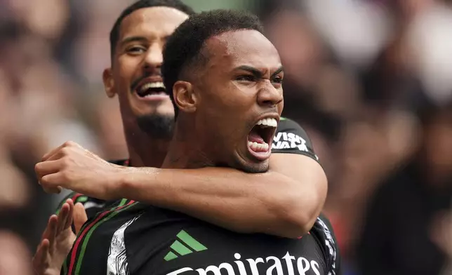 Arsenal's Gabriel, foreground, celebrates with teammate William Saliba after scoring the opening goal during the English Premier League soccer match between Tottenham Hotspur and Arsenal in London, Sunday, Sept. 15, 2024. (John Walton/PA via AP)