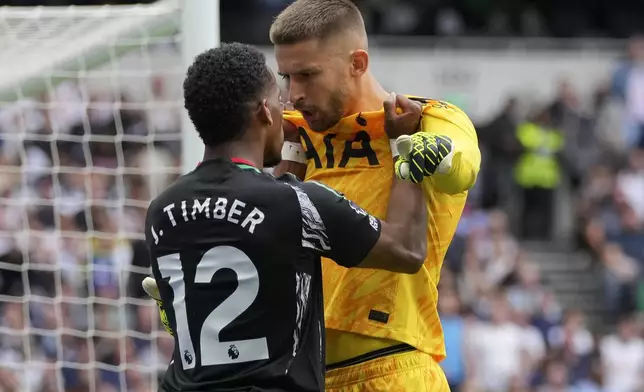 Arsenal's Jurrien Timber and Tottenham's goalkeeper Guglielmo Vicario square-up to each other during the English Premier League soccer match between Tottenham Hotspur and Arsenal in London, Sunday, Sept. 15, 2024. (AP Photo/Kin Cheung)