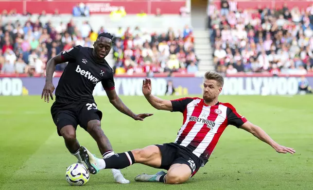 West Ham United's Michail Antonio (left) and Brentford's Ethan Pinnock battle for the ball during the British Premier League soccer match between West Ham and Brentford, at the Gtech Community Stadium, London, Saturday Sept. 28, 2024. (Rhianna Chadwick/PA via AP)