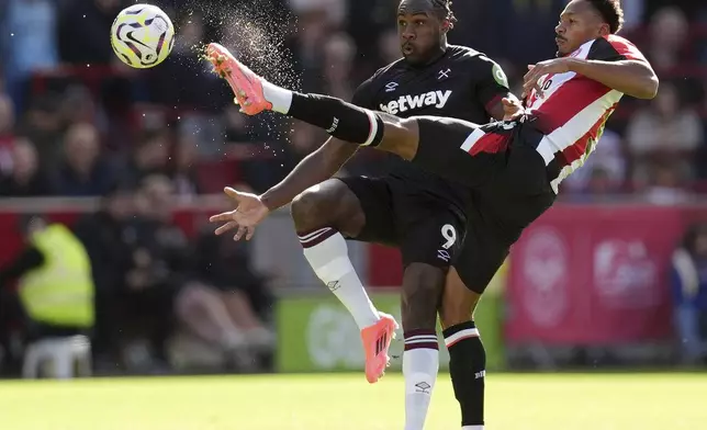 West Ham United's Michail Antonio (left) and Brentford's Ethan Pinnock battle for the ball during the British Premier League soccer match between West Ham and Brentford, at the Gtech Community Stadium, London, Saturday Sept. 28, 2024. (John Walton/PA via AP)