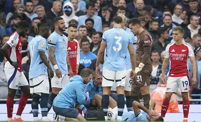 Manchester City's Rodri receives treatment during the English Premier League soccer match between Manchester City and Arsenal at the Etihad stadium in Manchester, England, Sunday, Sept. 22, 2024. (AP Photo/Dave Thompson)