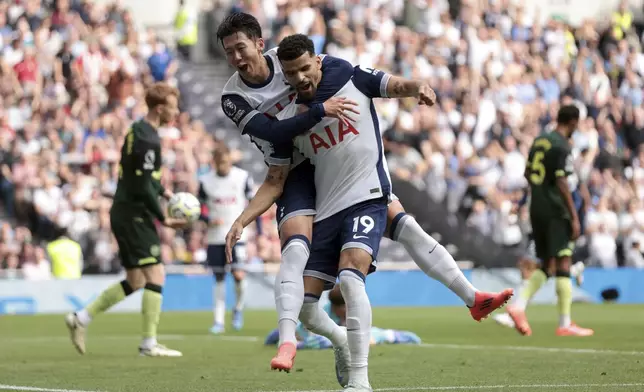 Tottenham Hotspur's Dominic Solanke, center, celebrates scoring his side's first goal of the game with teammate Son Heung-Min, during the English Premier League soccer match between Tottenham Hotspur and Brentford, at the Tottenham Hotspur Stadium, in London, Saturday, Sept. 21, 2024. (Steven Paston/PA via AP)