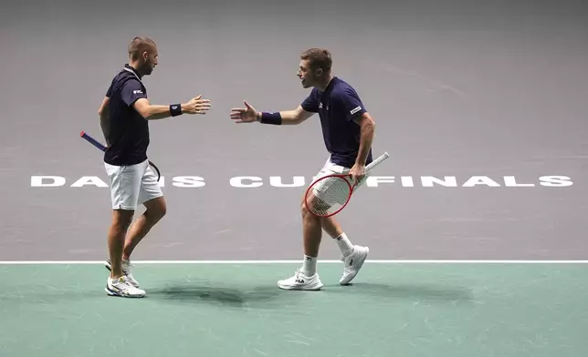 Great Britain's Dan Evans and Neal Skupski celebrate a point during the Davis Cup group stage finals match against Finland's Harri Heliovaara and Otto Virtanen at the AO Arena, in Manchester, England, Wednesday, Sept. 11, 2024. (Martin Rickett/PA via AP)