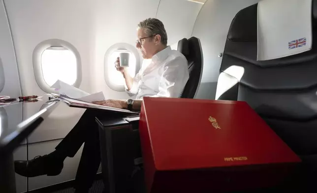 Britain's Prime Minister Keir Starmer works on the plane as he flies to Washington DC, for talks with President Joe Biden on resolving the conflicts in Ukraine and Gaza, Thursday, Sept. 12, 2024. (Stefan Rousseau/Pool Photo via AP)