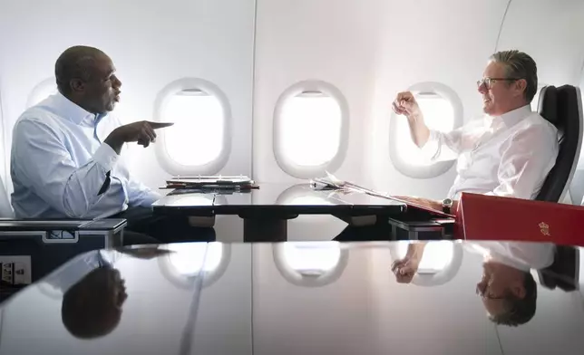 Britain's Prime Minister Keir Starmer, right, and Foreign Secretary David Lammy work on the plane as they fly to Washington DC, for talks with President Joe Biden on resolving the conflicts in Ukraine and Gaza, Thursday, Sept. 12, 2024. (Stefan Rousseau/Pool Photo via AP)