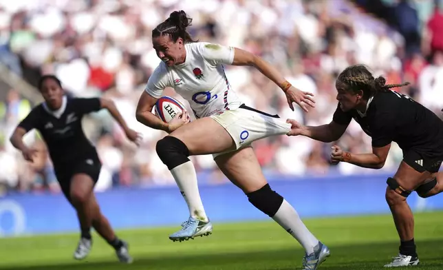 England's Emily Scarratt is tackled by New Zealand's Kennedy Tukuafu, right, during the Women's International match between England and New Zealand at Allianz Stadium, Twickenham, London, Saturday Sept. 14, 2024. (David Davies/PA via AP)