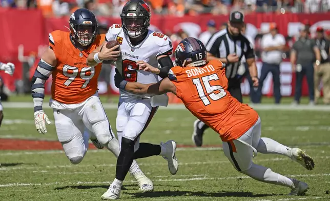 Tampa Bay Buccaneers quarterback Baker Mayfield (6) is stopped as he tries to get between Denver Broncos linebacker Nik Bonitto (15) and defensive end Zach Allen (99) during the second half of an NFL football game, in Tampa, Fla. on Sunday, Sept. 22, 2024. (AP Photo/Jason Behnken)